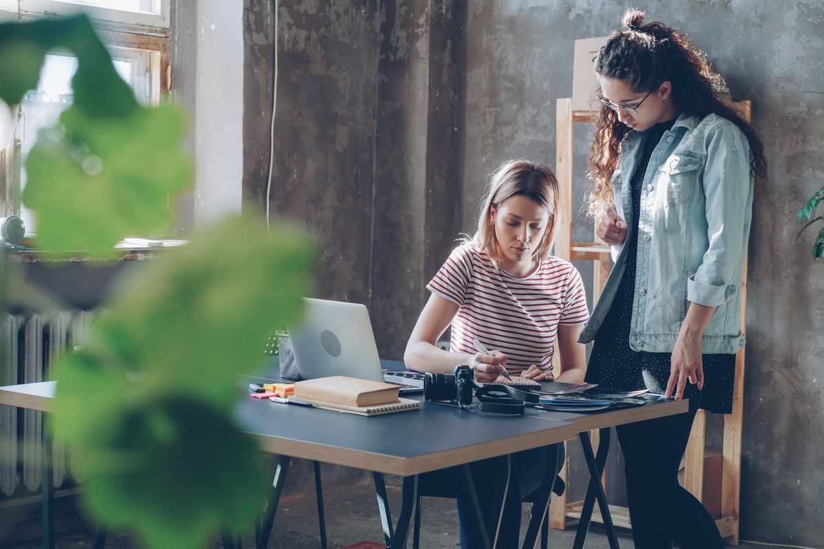 Two colleagues going through work on a laptop
